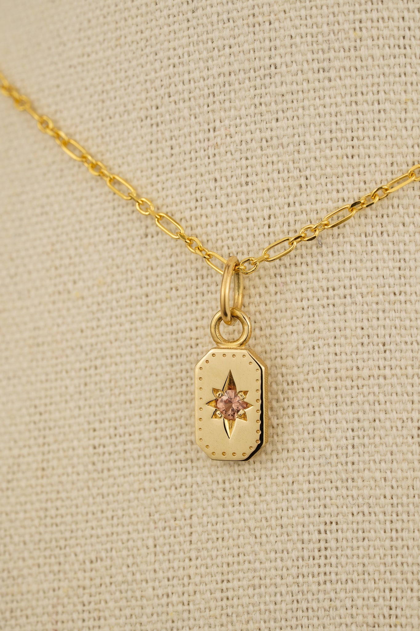 Solid gold emerald cut pendant with peach sapphire