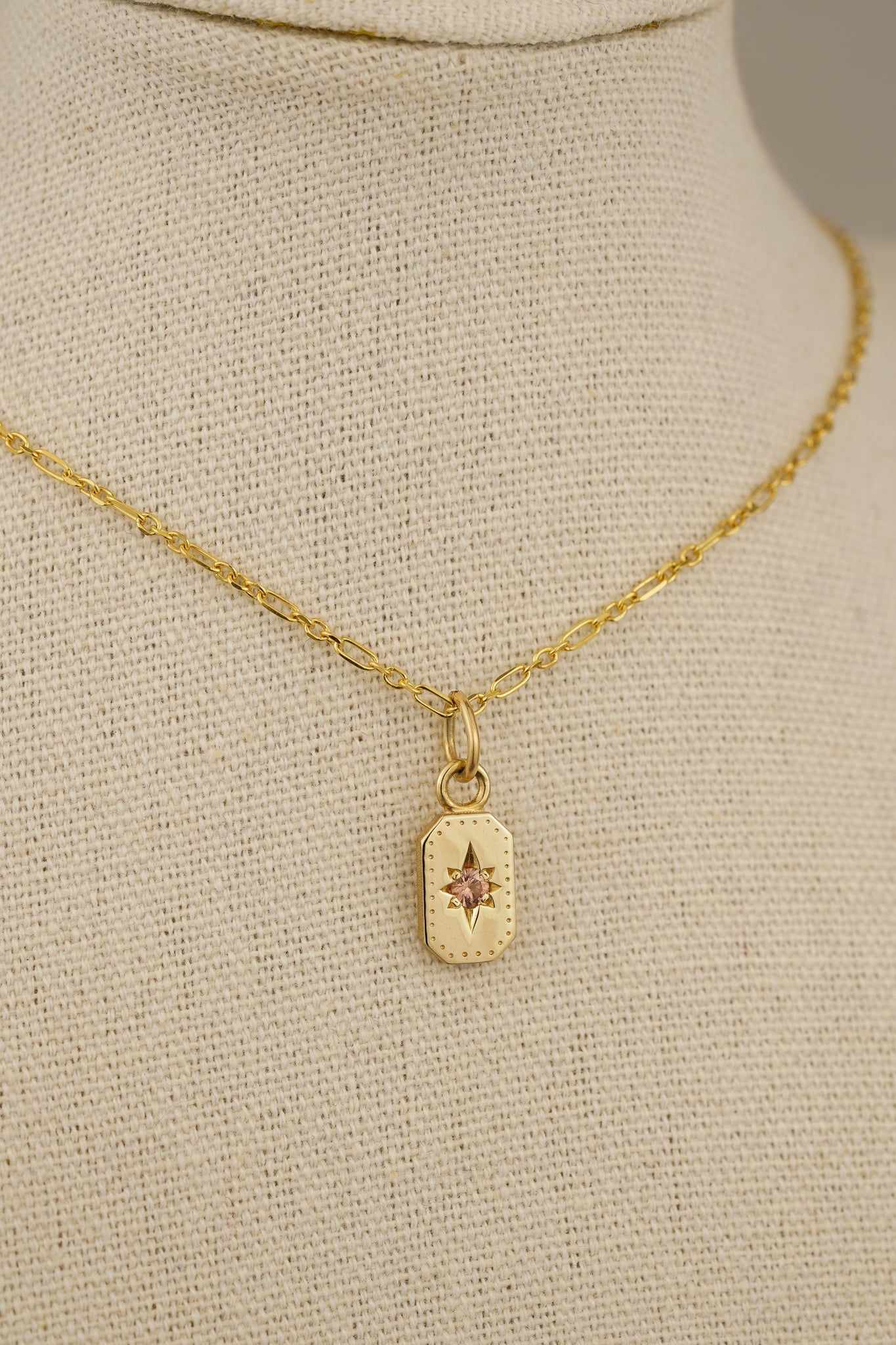 Solid gold emerald cut pendant with peach sapphire