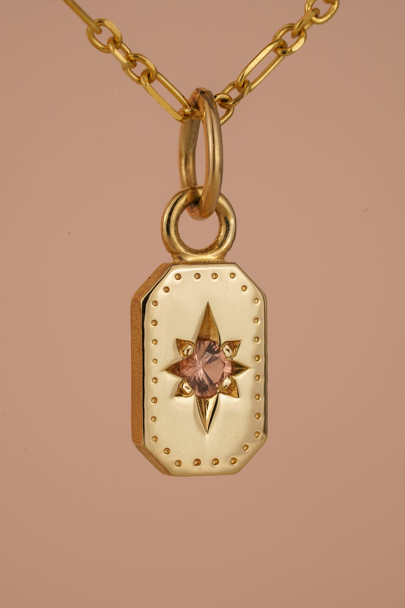 Solid gold emerald cut pendant with peach sapphire