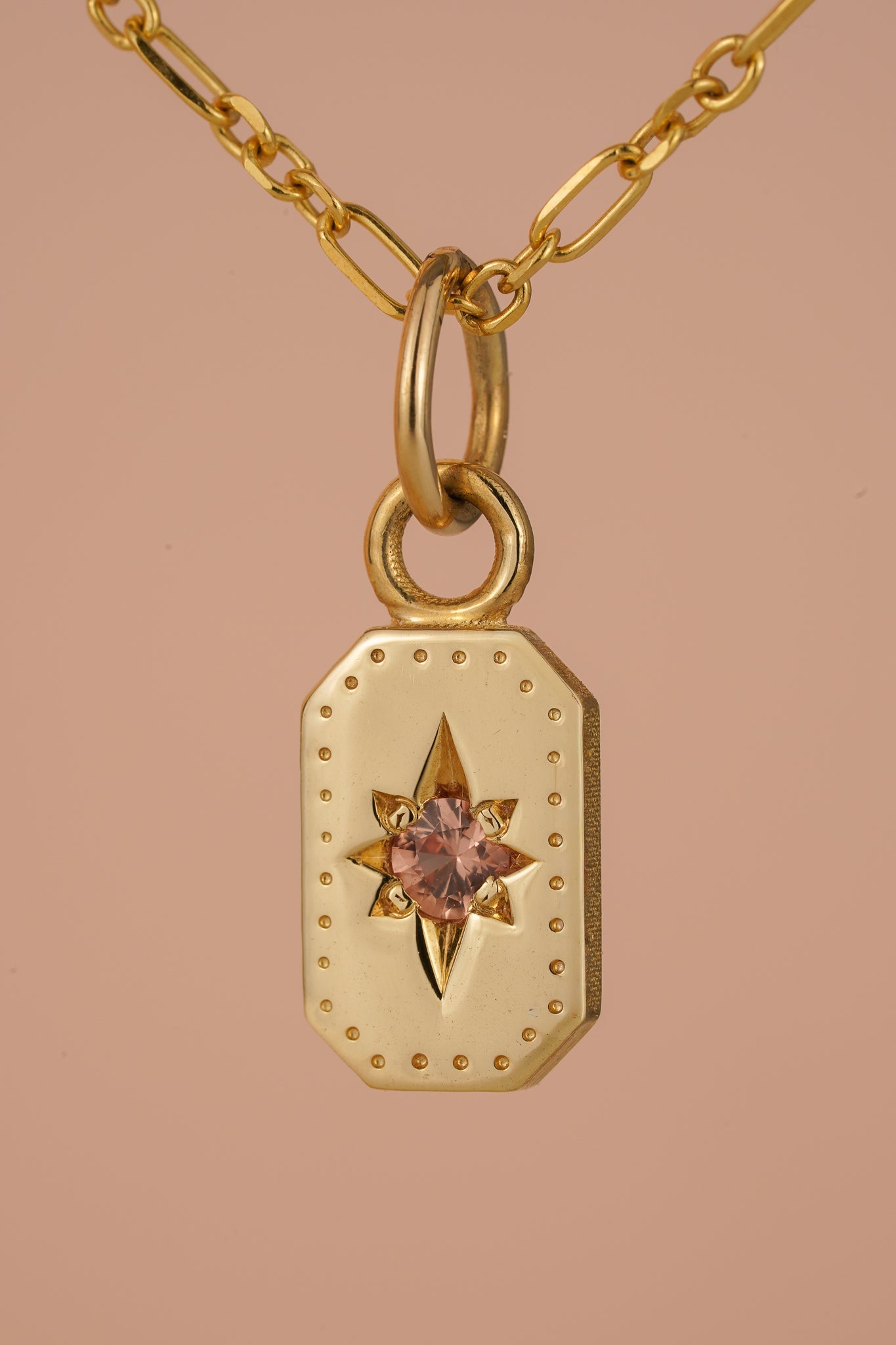 Solid gold emerald cut pendant with peach sapphire