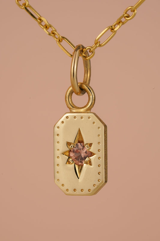 Solid gold emerald cut pendant with peach sapphire