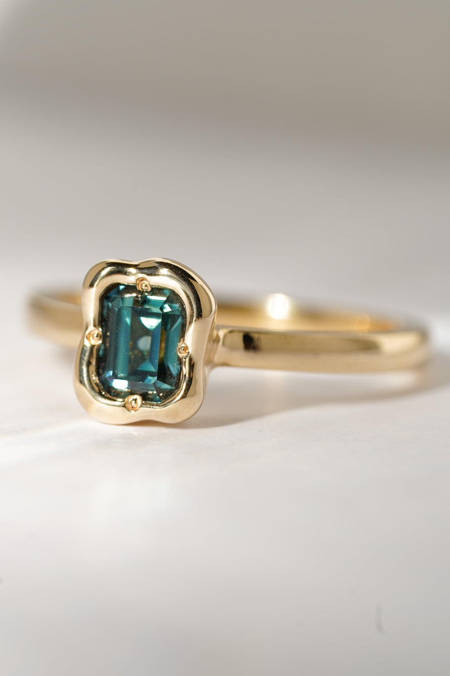 Solid gold deep teal sapphire solitare