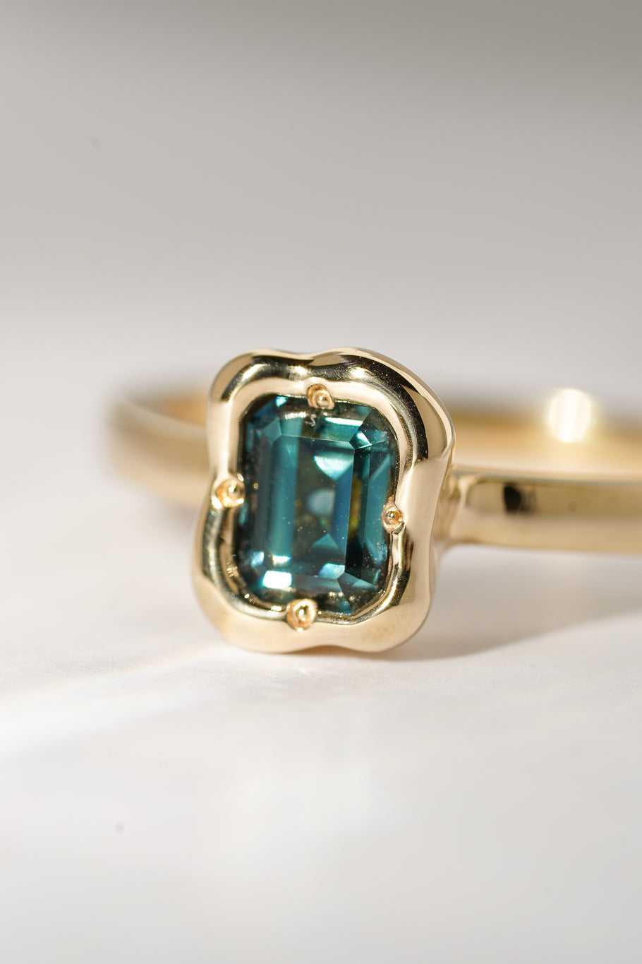 Solid gold deep teal sapphire solitare