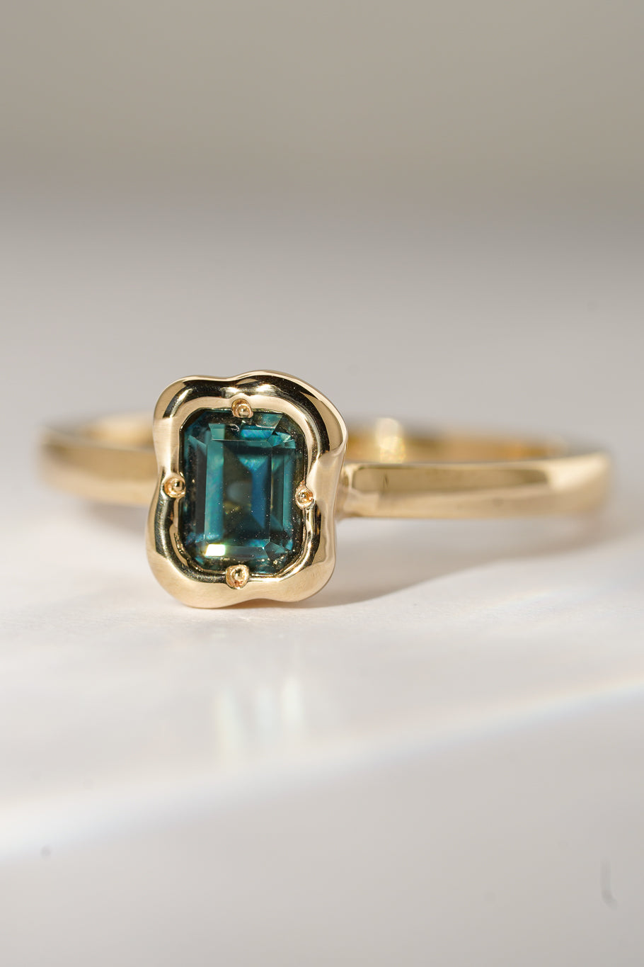 Solid gold deep teal sapphire solitare