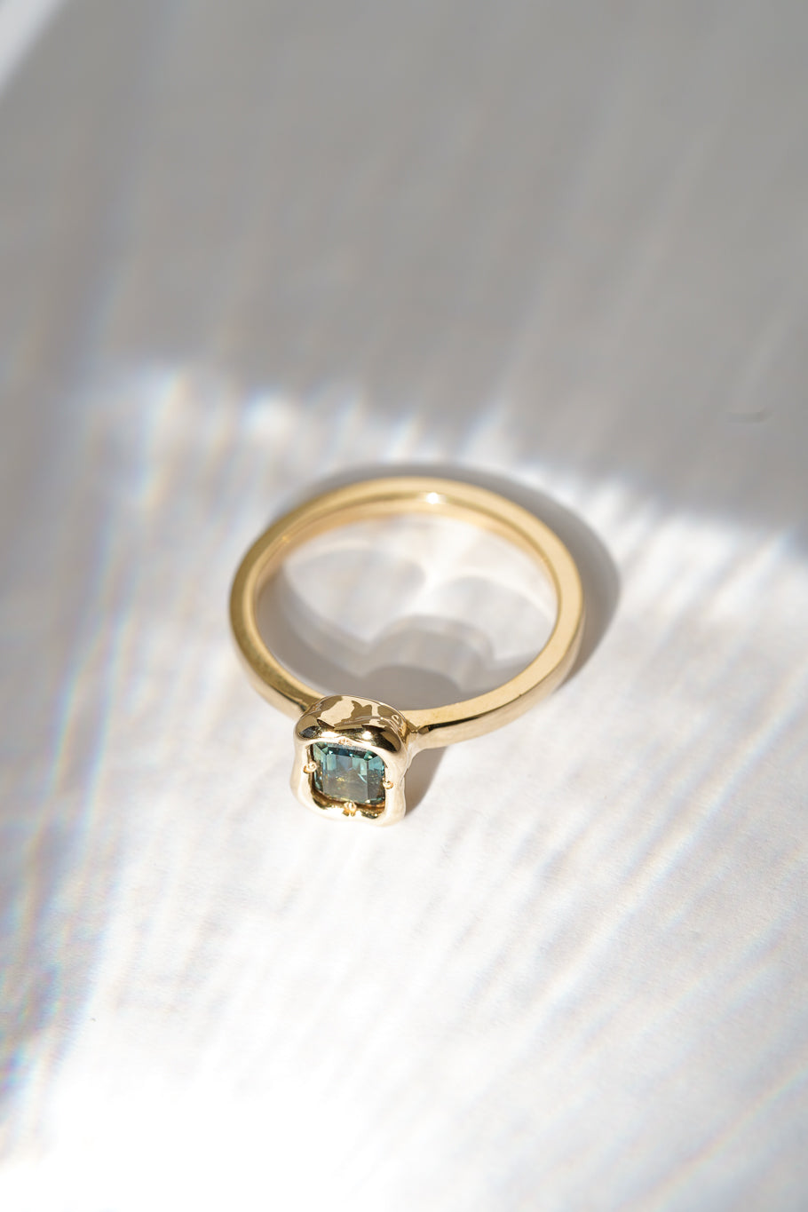 Solid gold deep teal sapphire solitare