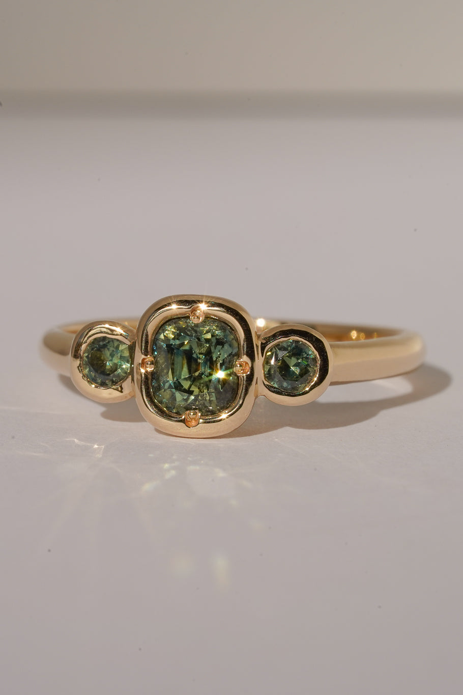 Solid gold green sapphire trilogy ring