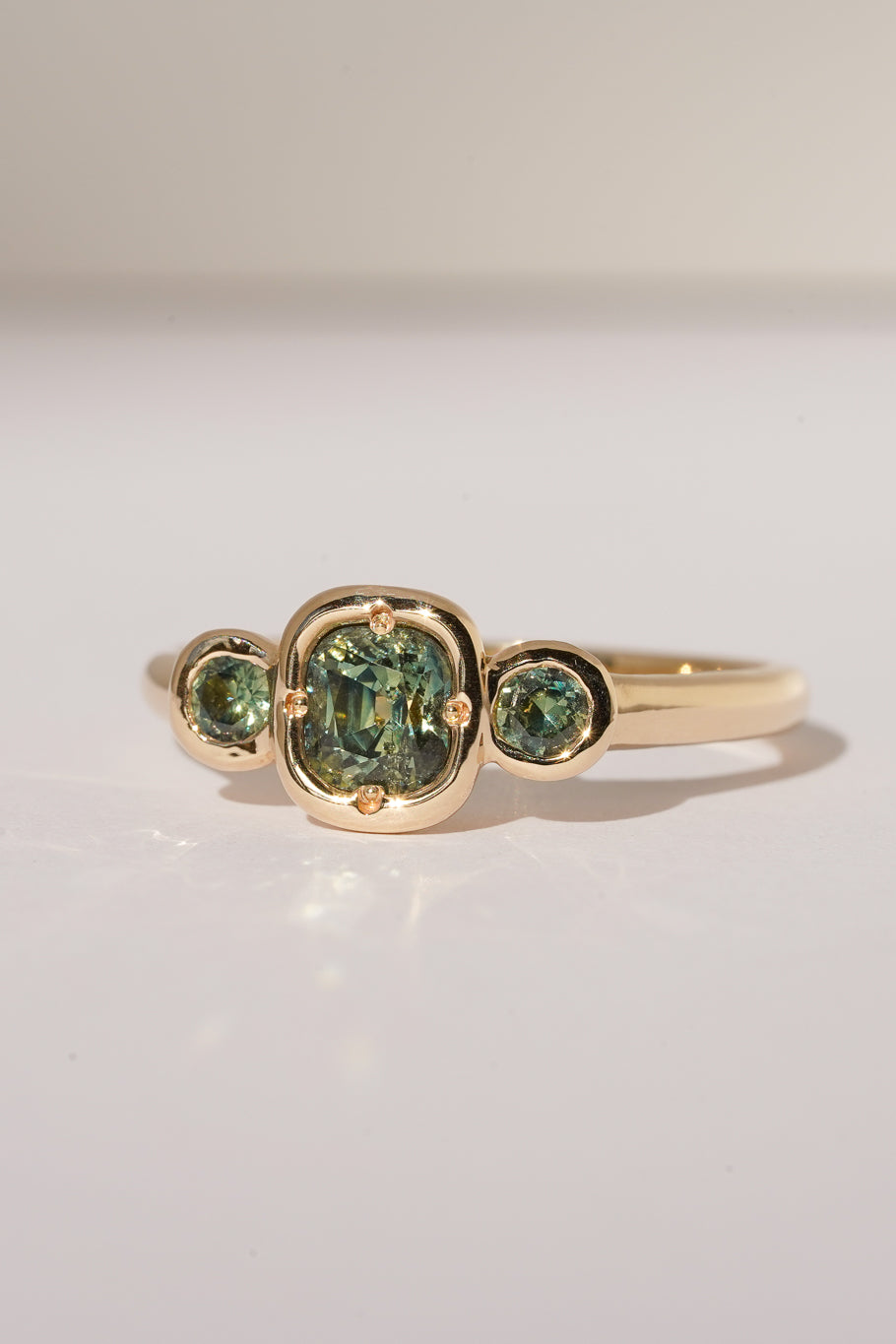 Solid gold green sapphire trilogy ring