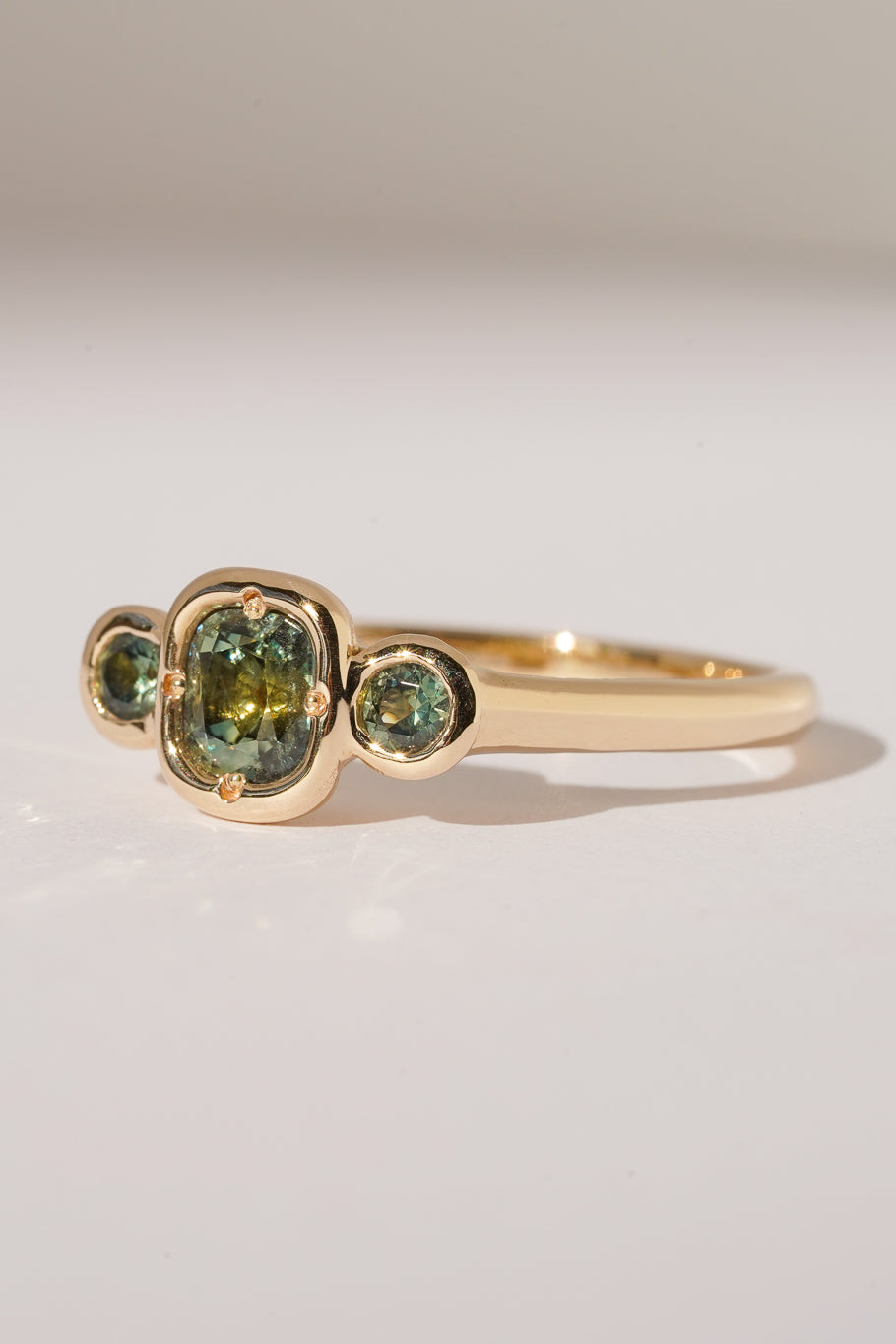 Solid gold green sapphire trilogy ring