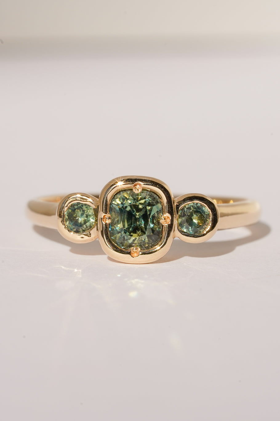 Solid gold green sapphire trilogy ring