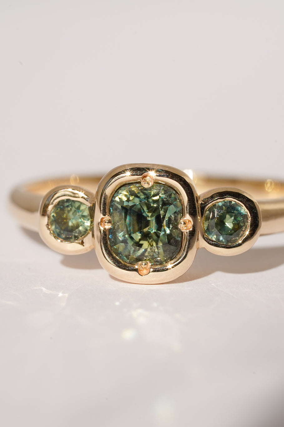 Solid gold green sapphire trilogy ring