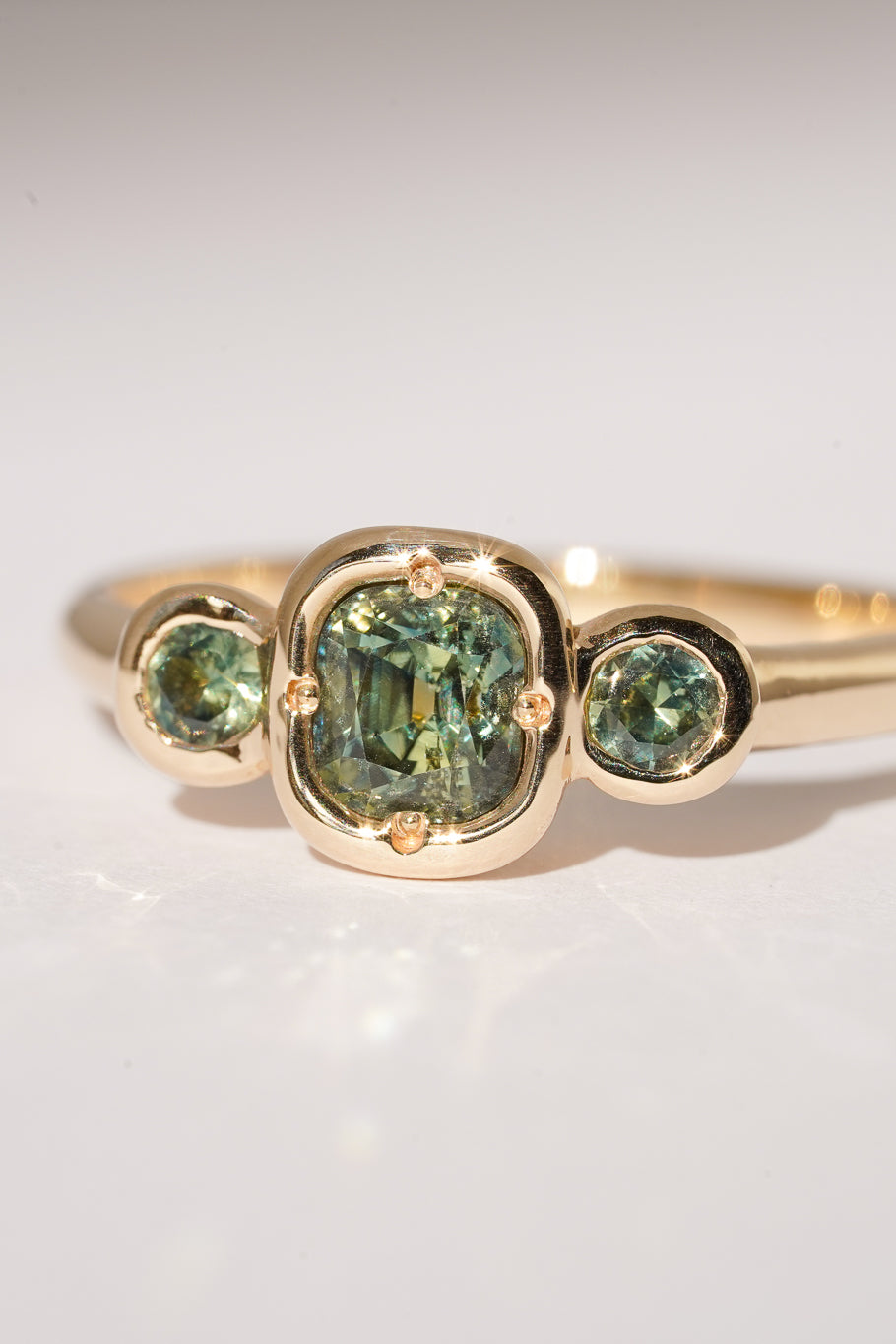 Solid gold green sapphire trilogy ring