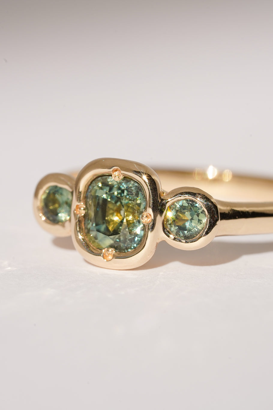 Solid gold green sapphire trilogy ring