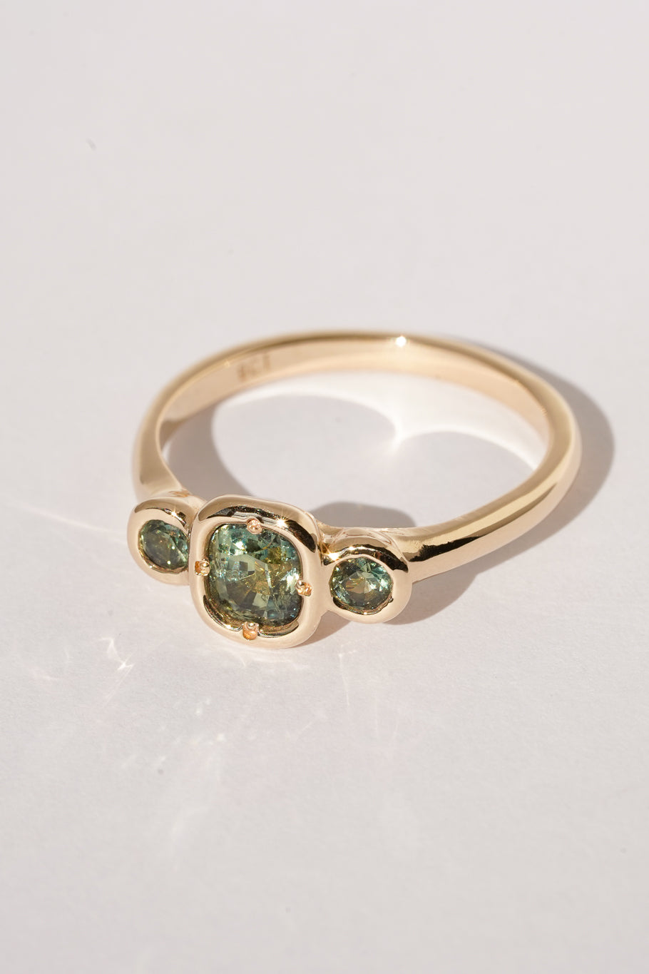 Solid gold green sapphire trilogy ring